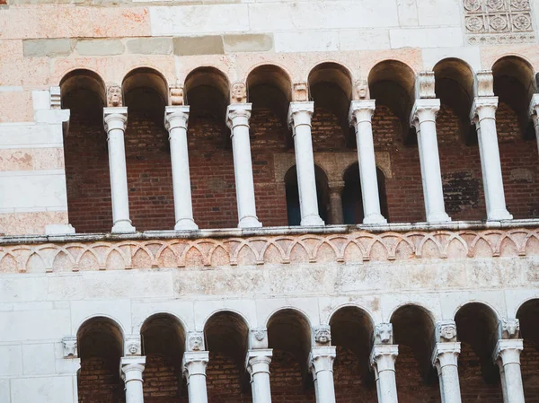 Cremona Katedrali, ortaçağ mimari sanatını vurgulayarak, tarihsel cephesinde ayrıntılı şekillendirilmiş büyük harflerle sıralanmış Romanca kütükler, kemerler ve süslü mermer sütunlar sergiliyor.