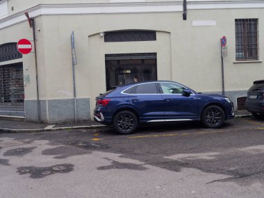 Cremona, İtalya - 3 Şubat 2026 Modern bir koyu mavi Audi Q3 Sportback şehir sokaklarında park halinde, bulutlu bir gökyüzü altında şık coupe-SUV tasarımı sergiliyor.