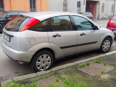 Cremona, İtalya - 3 Şubat 2026 Gümüş renkli bir Ford Focus hatchback, belirgin bir şekilde düz bir arka lastik ve aşınma izleri gösteren bir kaldırım kenarında park halinde.