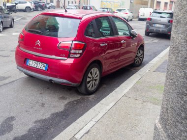Cremona, İtalya - 3 Şubat 2026 canlı kırmızı bir Citroen C3 hatchback asfalt bir sokakta park halinde, arka tasarımı ve İtalyan plakası sergilenmektedir.