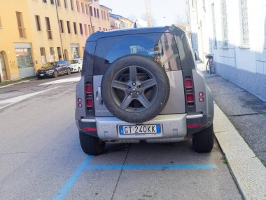 Cremona, İtalya - 3 Şubat 2026 Bir İtalyan plakalı Land Rover Defender SUV, arka tasarımı ve yedek lastiği ile şehir hareketliliğini ve modern