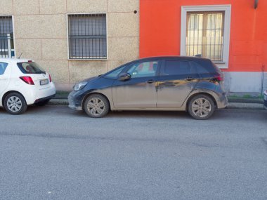 Cremona, İtalya - 3 Şubat 2026 Kirli, koyu mavi bir hatchback asfalt yolda park edilmiş,