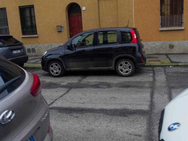 Cremona, İtalya - 3 Şubat 2026 Bir kompakt siyah Fiat Panda arka planda ikametgah binaları olan bir caddede park halinde, kentsel hizmetlerini sergiliyor
