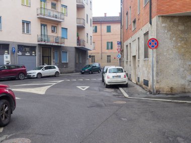 Cremona, İtalya - 3 Şubat 2026 Kenar boyunca park edilmiş dar bir caddenin manzarası, çeşitli trafik işaretleri ile birlikte