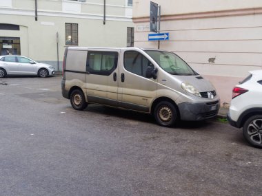 Cremona, İtalya - 3 Şubat 2026 Renault Trafic ticari aracı, mal ve teslimat için bir araç, ıslak asfaltlı bir şehir caddesinde beyaz bir Honda HR-V ile park edilmiş.