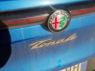 Cremona, İtalya - 3 Şubat 2026 Alfa Romeo Tonale premium SUV tozlu mavi bagaj kapağında marka kimliği ve modern İtalyan otomotiv özelliklerini vurgulayan sembolik amblem ve modelini barındırır.