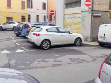Cremona, İtalya - 26 Şubat 2026 Beyaz bir Alfa Romeo Giulietta Avrupa 'nın bir şehrinde, diğer araçlar ve renkli binalarla çevrili bir caddede park halinde.