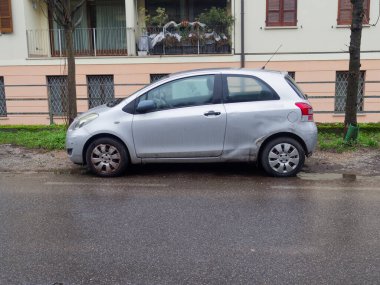 Cremona, İtalya - 23 Şubat 2026 Üç kapılı gümüş bir Toyota Yaris hatchback, arka panelindeki çizikleri ve çizikleri gösteriyor.