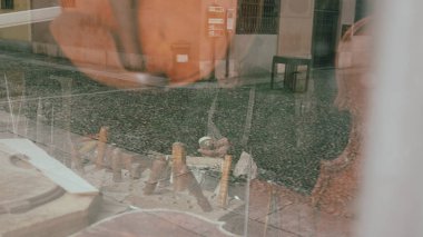 Bir zanaatkar geleneksel Cremona atölyesinde aletler ve malzemelerle çevrili bir keman parşömenini titizlikle şekillendirir.