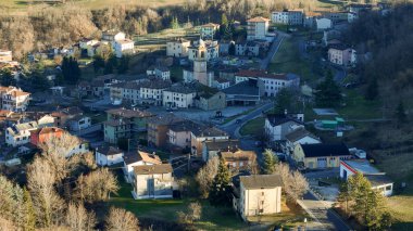 Havadan bakıldığında büyüleyici İtalyan köyü Morfasso, kümelenmiş evleri ve dolambaçlı yolları ile sonbahar ağaçlarına karşı kurulmuş.