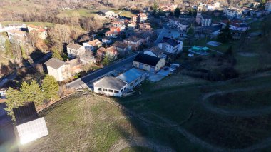 İnsansız hava aracı görüntüleri, yeşil tepelerin arasına yerleştirilmiş ve konut binaları ve güneş enerjisi altyapısının yer aldığı pitoresk bir İtalyan köyü olan Morfasso 'yu çekiyor.