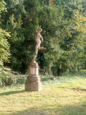 Busseto, İtalya - 11 Ekim 2025 Sant 'Agata Villa Verdi tarihi bahçesinde bereketli yeşillik ve çimlerle çevrili taş bir heykel yer alıyor.