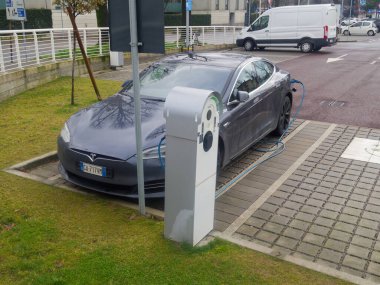 Cremona, İtalya - 17 Şubat 2026 Pırıl pırıl gri bir elektrikli araç bir şarj istasyonuna bağlandı.