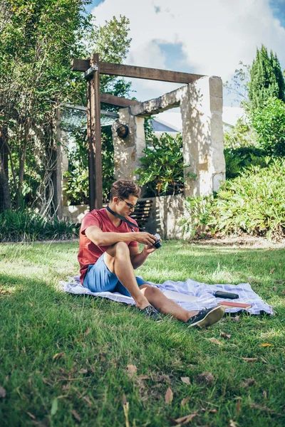 Young man using vintage camera in park — Stock Photo, Image