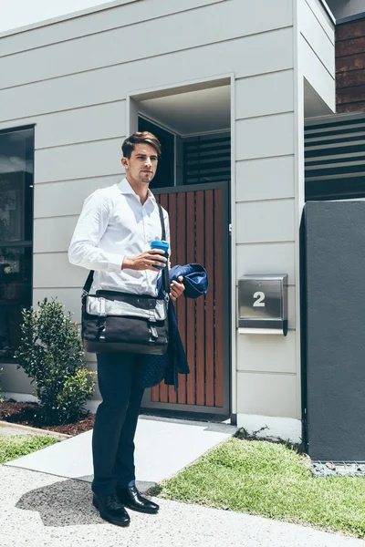 Jeune homme debout devant son appartement moderne Photo De Stock