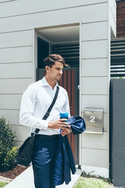 若い男彼の近代的なアパートの外に立って ロイヤリティフリーのストック画像
