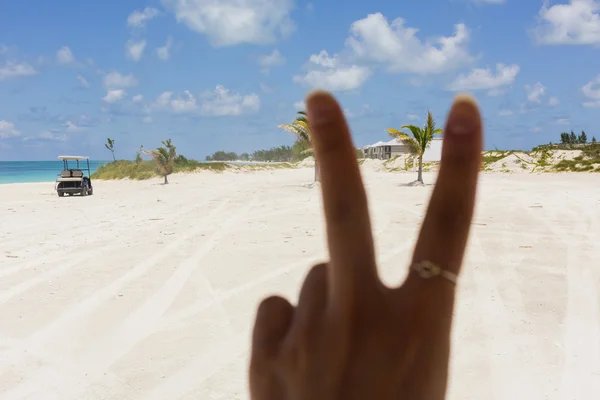 Afbeelding van de vingers maken het vredesteken op het strand — Stockfoto