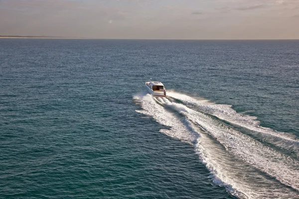 Small boat sailing through a calm sea Stock Photo