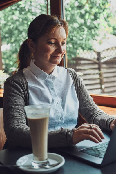 Gülümseyen Mutlu Kadını Dizüstü Bilgisayarıyla Çalışıyor Bilgisayarını Yönetiyor Bir Kafede — Stok fotoğraf