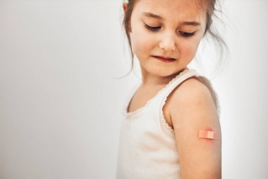 Küçük kız aşıdan sonra bazı yan etkiler göstererek acı çekiyor. Kırmızılık, şişkinlik, ağrıyan uzuvlar ve aşıdan sonra baş ağrısı. İlk iğneyi yaptırıyorum. Sağlıklı ve tıbbi konsept