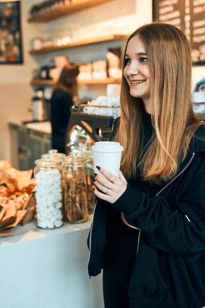 Kobieta Trzymająca Filiżankę Kawy Stojąca Kawiarni Czekająca Zamówienie Uśmiechnięta Młoda — Zdjęcie stockowe