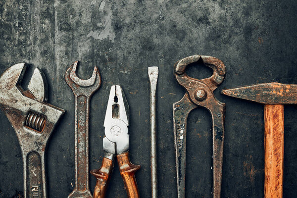 Old hardware tools. Wrench, screwdriver, measure, hammer, pliers on steel surface. Mechanic tools for maintenance. Hardware tools to fix. Technical background with copy space