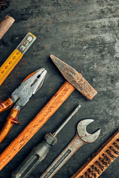 Old hardware tools. Wrench, screwdriver, measure, hammer, pliers on steel surface. Mechanic tools for maintenance. Hardware tools to fix. Technical background with copy space