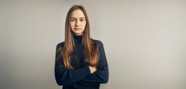 Genç bir kadının portresi. Pozitif ruh halinde klasik portre, stüdyoda poz veren güzel model kameraya bakıyor.