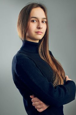 Genç bir kadının portresi. Pozitif ruh halinde klasik portre, stüdyoda poz veren güzel model kameraya bakıyor.