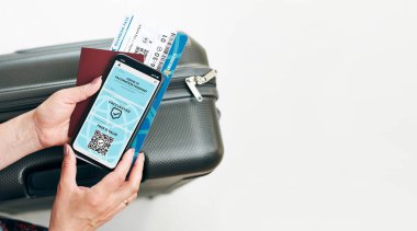 Dijital covid sertifikası. Covid negatif hızlı dijital test geçişi. Cep telefonu, pasaport ve uçak biletinde dijital kimlik kartı olan bir kadın. Sayısal covid test sonuçlarını covid-19 p sırasında seyahat için tıbbi geçiş olarak gösteren gezgin