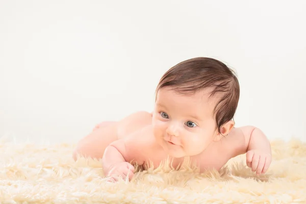 毛皮で覆われた毛布の上に横たわる女の赤ちゃん — ストック写真