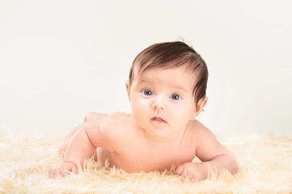 Baby girl lying on furry blanket — Stock Photo, Image