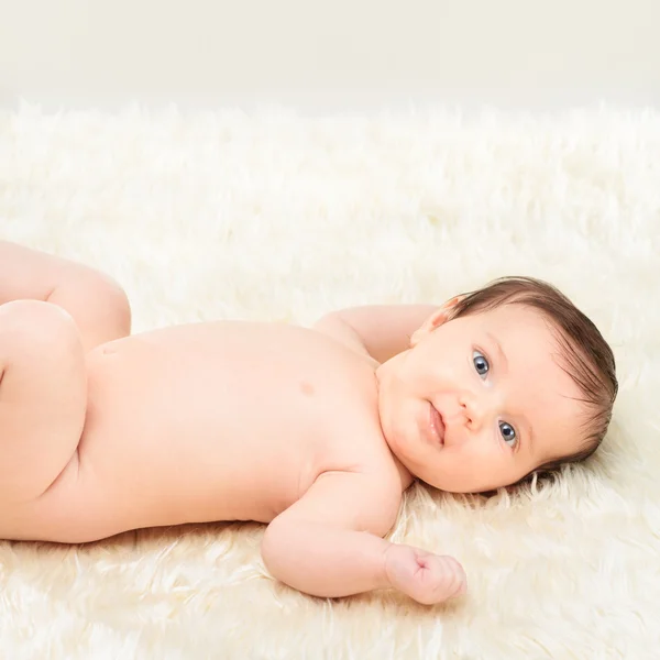 Bebê menina deitada no cobertor peludo — Fotografia de Stock