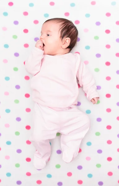 Little baby lying on blanket with colourful polka dots — Stock Photo, Image