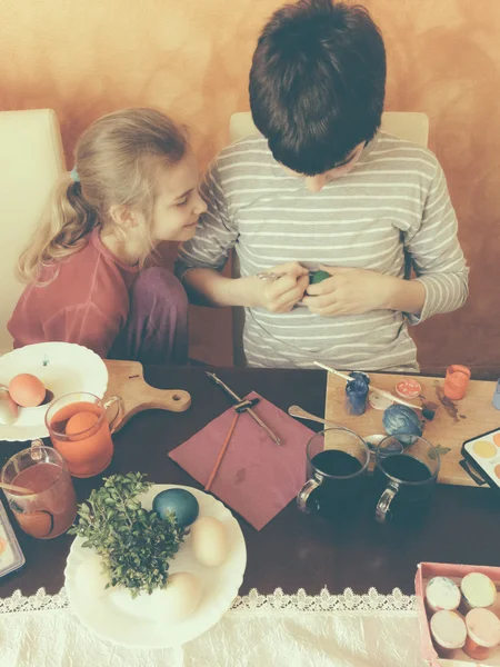 Brother and sister painting Easter eggs at home — Stock Photo, Image