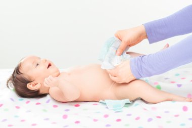 Küçük bebek kızı değişen anne bebek bezi