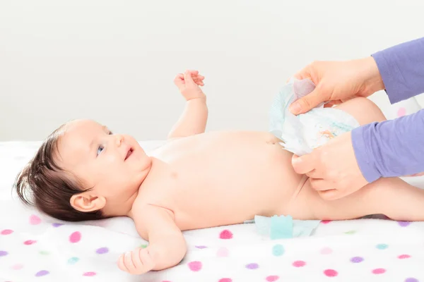 Moeder veranderen luier haar babymeisje — Stockfoto