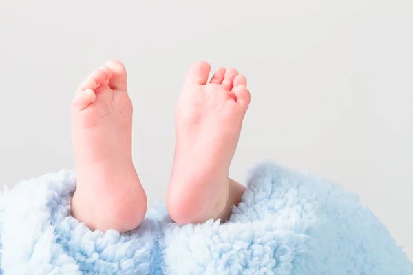 Pés de bebê deitado em cobertor — Fotografia de Stock