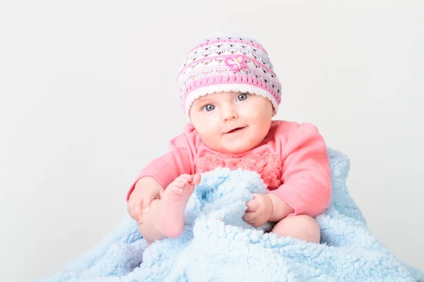 Pequena menina sorrindo sentada no cobertor — Fotografia de Stock
