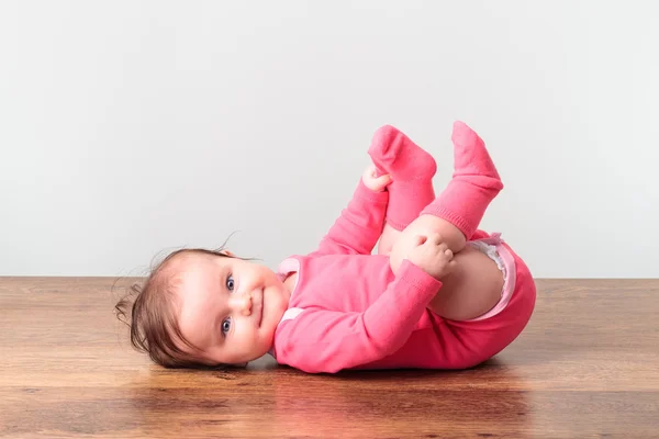 Little baby girl playing with her feet — Stock Photo, Image