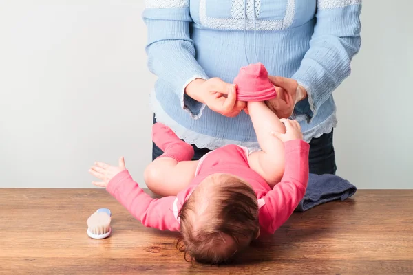 Mama wprowadzenie na skarpetki jej małą córeczkę — Zdjęcie stockowe