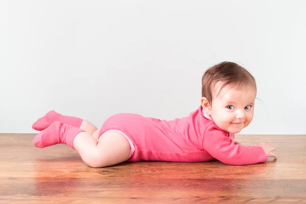 Smiling little baby girl playing on the floor — Stock Photo, Image
