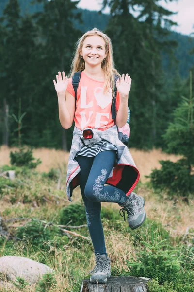 Playful girl posing on a tree trunk — Stock Photo, Image