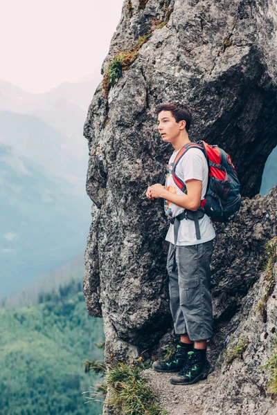 Ragazzo in piedi sulle rocce in montagna — Foto Stock