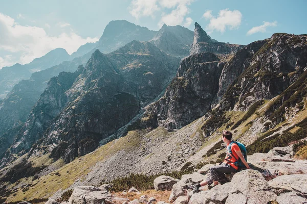 Junge ruht auf einem Felsen in den Bergen — Stockfoto