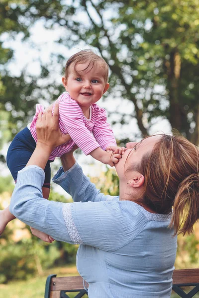 Mor leger med sin lille datter i haven - Stock-foto