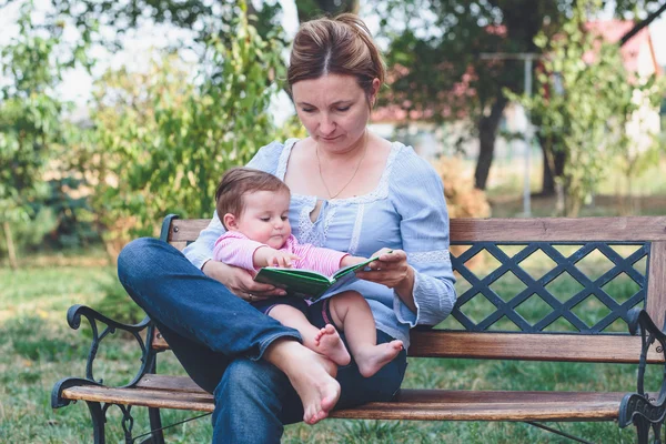 Mamá leyendo un libro su hijita — Foto de Stock