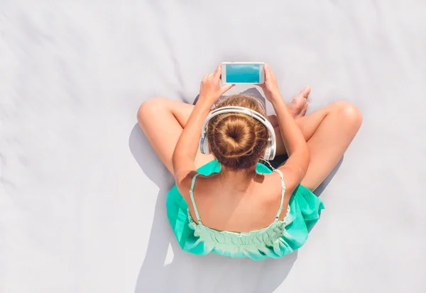 Chica joven escuchando música desde el teléfono móvil — Foto de Stock