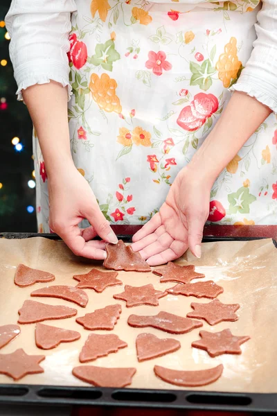 Frau schneidet Weihnachtssymbole aus dem Teig für den Kakao — Stockfoto