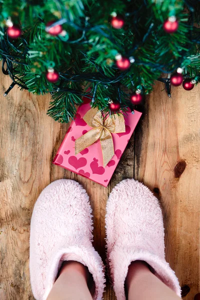 Criança olhando para baixo no presente sob a árvore de Natal — Fotografia de Stock